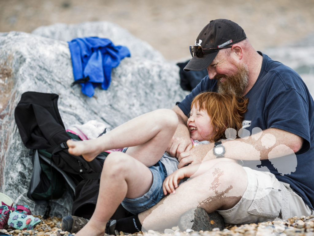 The Dads Network Groups - Father and daughter hugging on beach